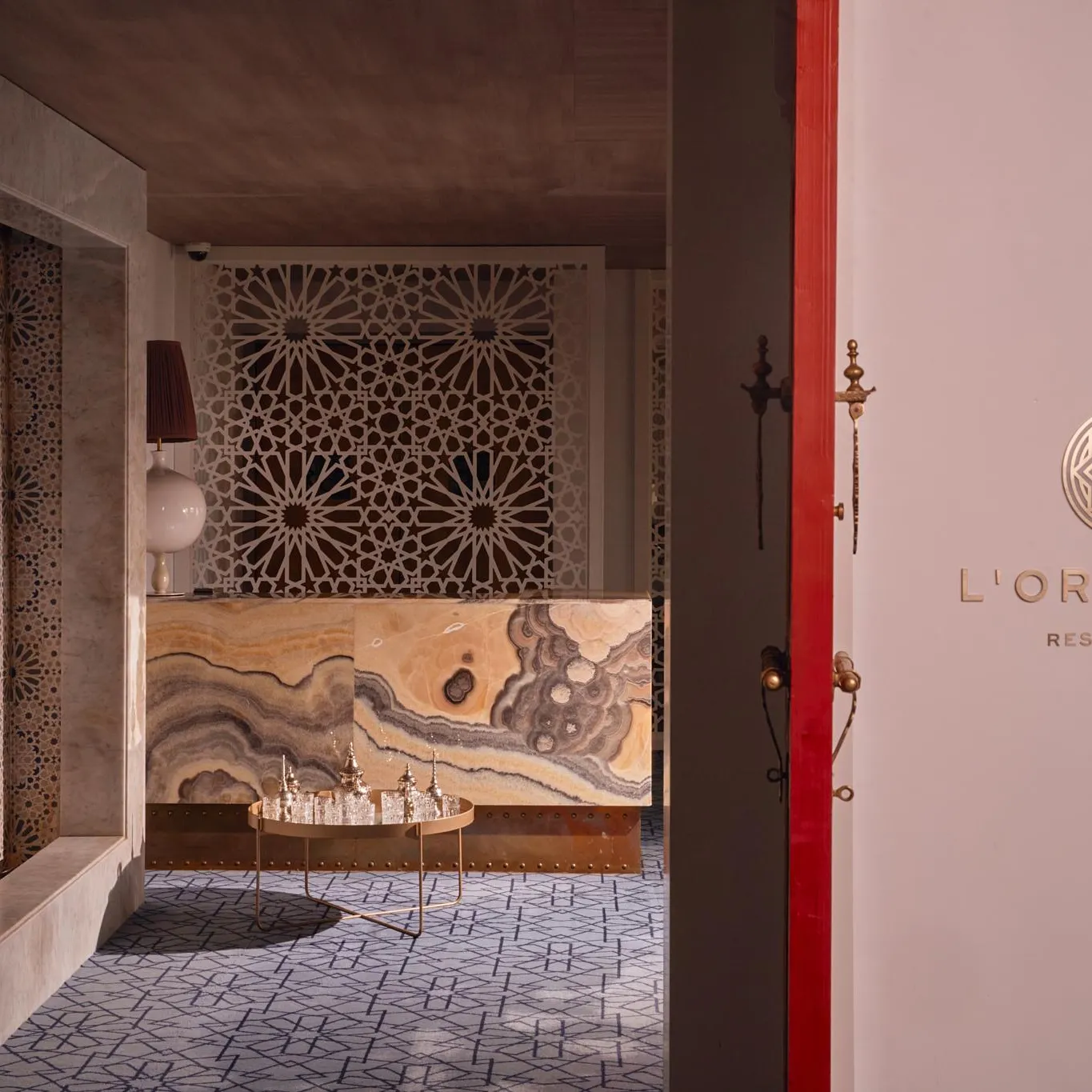 View from inside a restaurant named L'Orientin, with geometric wall decor and a marble counter