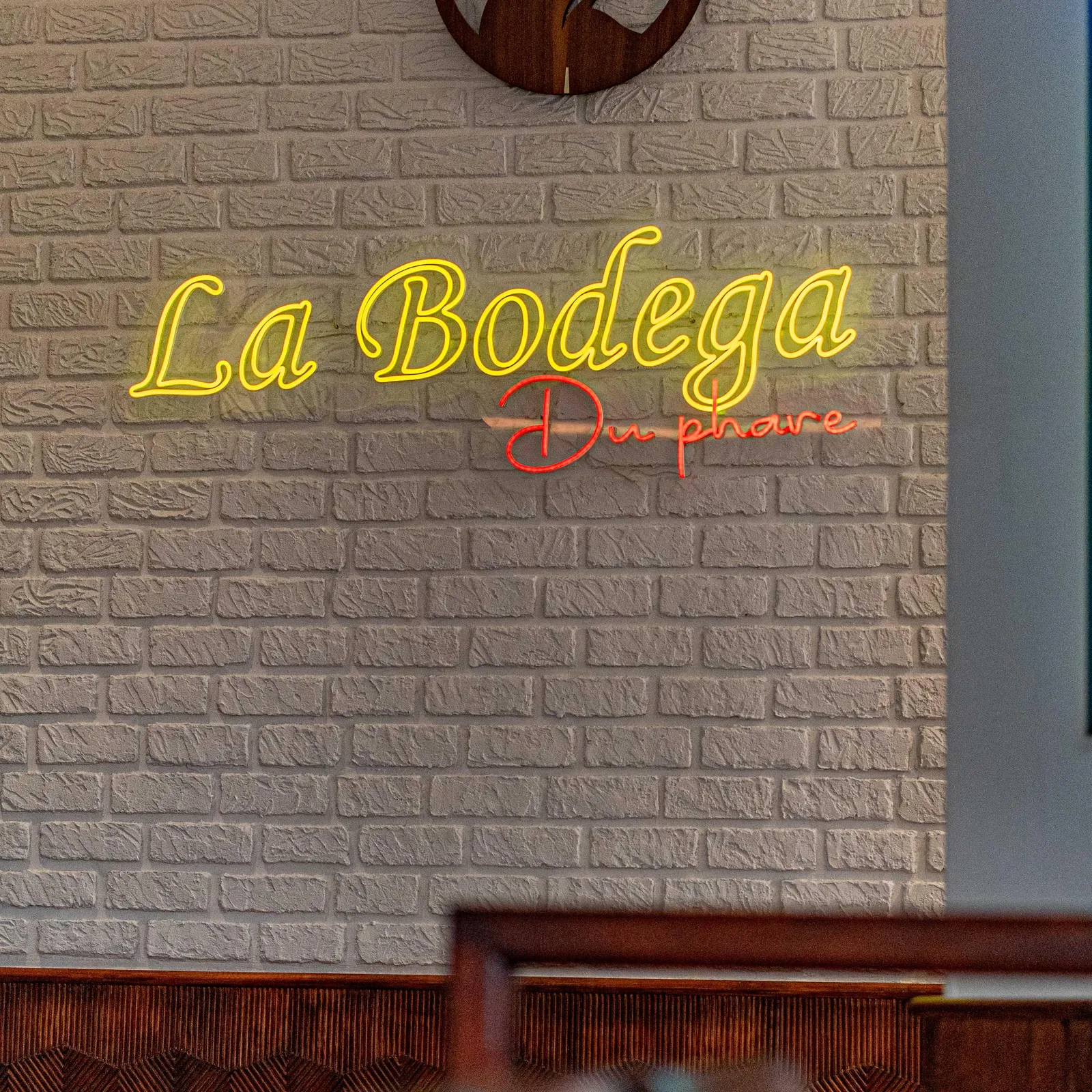 Brick wall with the illuminated sign "La Bodega" and a bull logo above