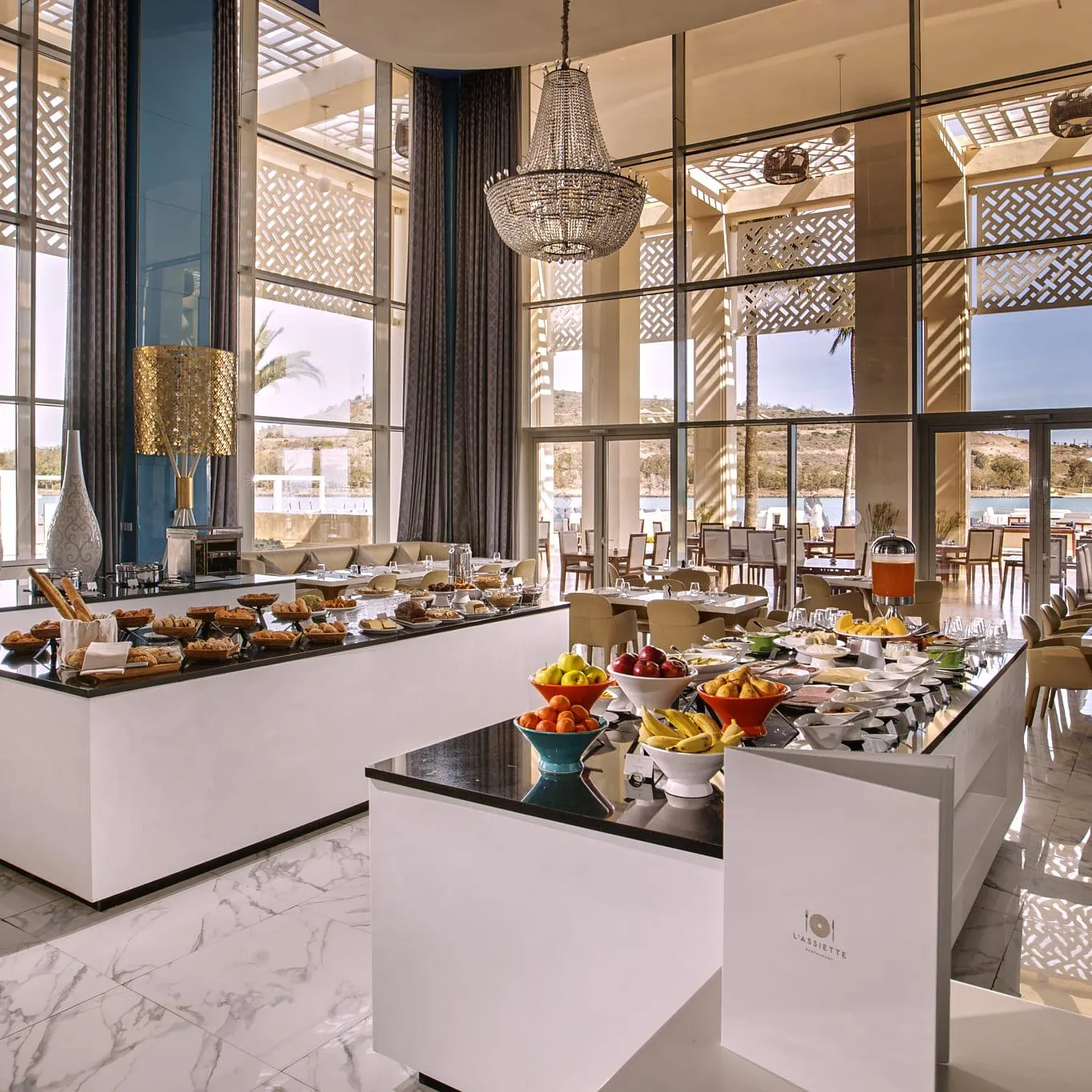 Elegant restaurant with breakfast buffet, large windows, and sea view