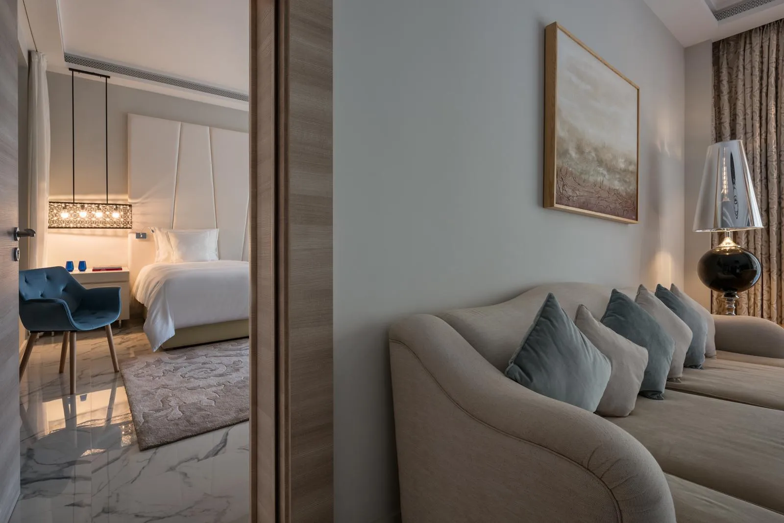 Chambre d'hôtel moderne avec lit, canapé, table de travail et lampe de chevet